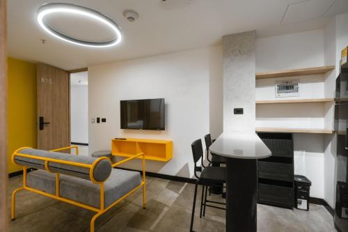 a living room with a tv and a table and chairs at Indie Universe Creative Hotel in Medellín