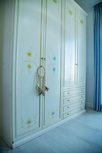 a room with a large white cabinet with flowers on it at Goccia Bianca - Gocce sul Mare in Savelletri di Fasano