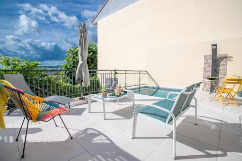 patio con sedie, ombrellone e piscina di Kaz Azur a Fort-de-France
