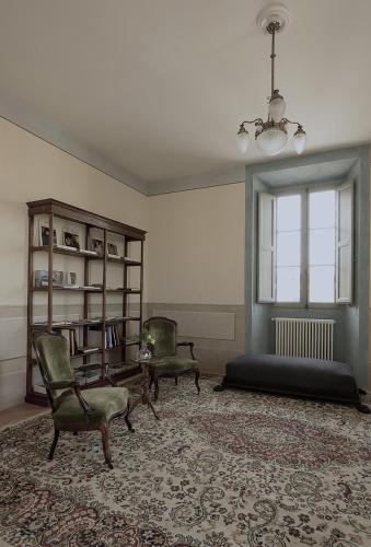 a living room with two chairs and a bed at B&B Palazzo Mattei in Novafeltria