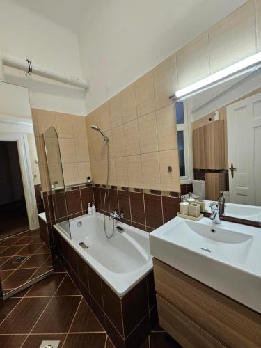 a bathroom with two sinks and a large mirror at Margaret Buda Apartman city view in Budapest