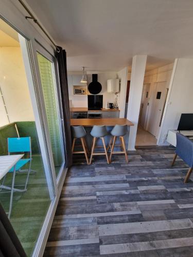 une cuisine et une salle à manger avec une table et des chaises dans l'établissement Cozy appartement t3 lumineux, à Bron