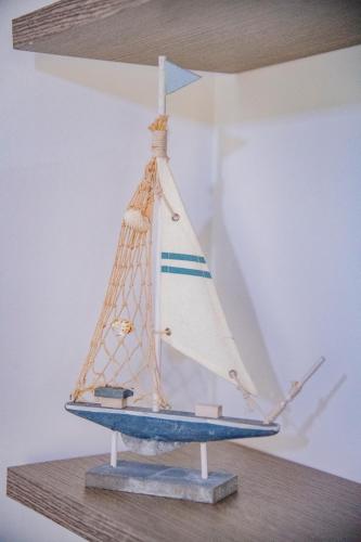 a wooden model of a sailboat on a shelf at Goccia Bianca - Gocce sul Mare in Savelletri di Fasano