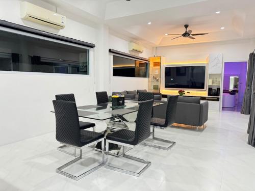 a dining room with a glass table and chairs at Secret Villa Private 4BR with Pool and Cinema in Amphoe Koh Samui