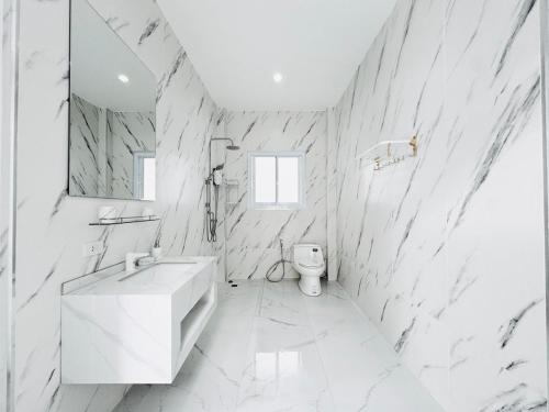 a white bathroom with a sink and a toilet at Secret Villa Private 4BR with Pool and Cinema in Amphoe Koh Samui