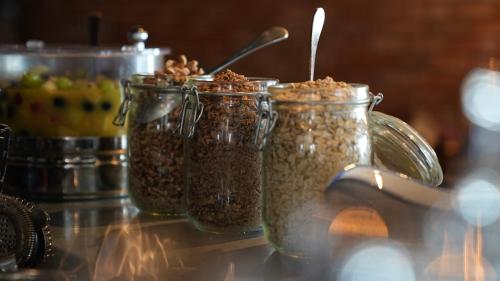 three jars of granola sitting on a counter at Fliegerdeich Hotel & Restaurant in Wilhelmshaven