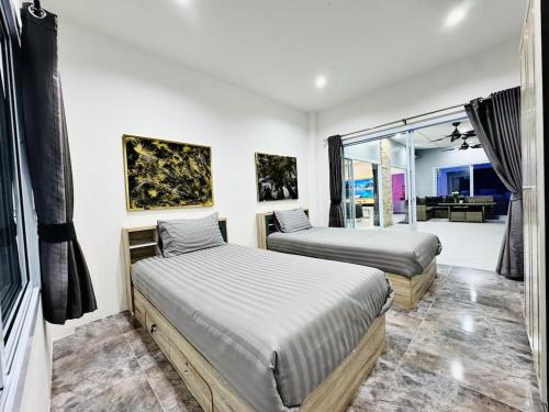a bedroom with two beds and a living room at Secret Villa Private 4BR with Pool and Cinema in Amphoe Koh Samui