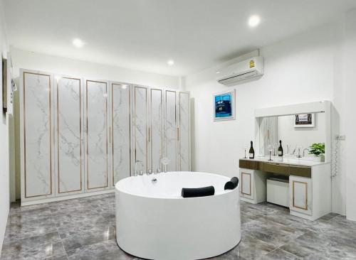 a white bathroom with a tub and a sink at Secret Villa Private 4BR with Pool and Cinema in Amphoe Koh Samui
