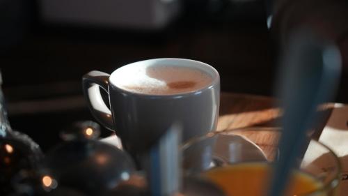 a cup of coffee sitting on a table at Fliegerdeich Hotel & Restaurant in Wilhelmshaven