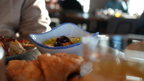 a bowl of food sitting on a table with food at Fliegerdeich Hotel & Restaurant in Wilhelmshaven