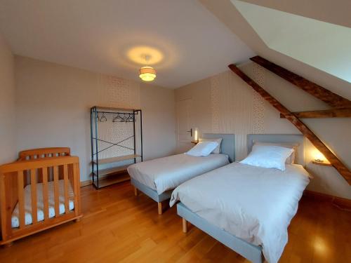 - une chambre avec 2 lits et un lit bébé dans l'établissement Le gîte du Cormier, à Saint-Aubin-du-Désert