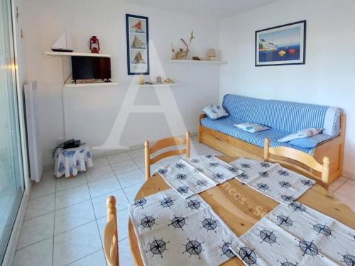 un salon avec une table et un canapé dans l'établissement Proche des plages, residence avec piscine, T2 equipe wifi avec garage, à Sète