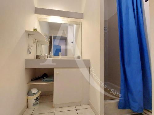 une salle de bain avec un lavabo et un miroir dans l'établissement Proche des plages, residence avec piscine, T2 equipe wifi avec garage, à Sète