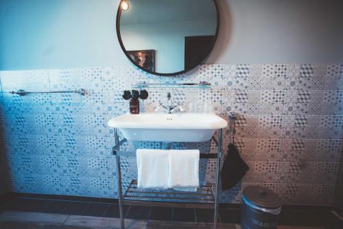a bathroom with a sink and a mirror at Fliegerdeich Hotel & Restaurant in Wilhelmshaven
