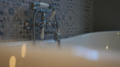 a bath tub with a faucet and a sink at Fliegerdeich Hotel & Restaurant in Wilhelmshaven