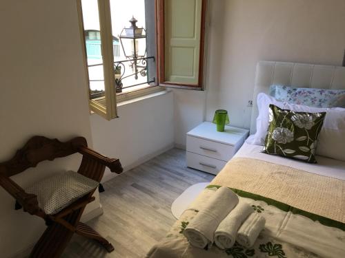 1 dormitorio con cama, ventana y silla en La Tana Dei Leoni Affittacamere, en Florencia
