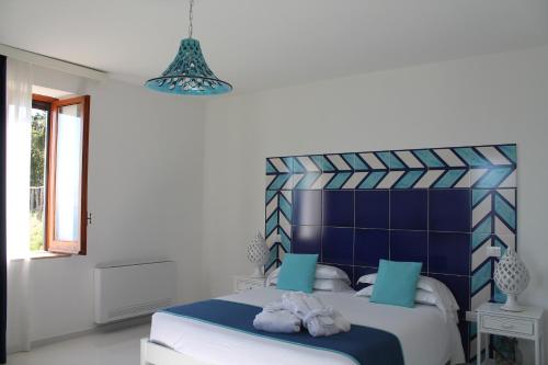 a bedroom with a blue and white bed with towels on it at Il Melograno in Costa d'Amalfi - romantic experience in Vietri sul Mare