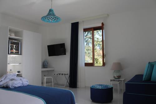a bedroom with a blue bed and a window at Il Melograno in Costa d'Amalfi - romantic experience in Vietri sul Mare