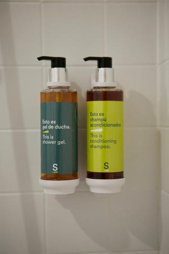 two bottles of hair products sitting on a wall at Hotel Sercotel Ciutat D'Alcoi in Alcoy
