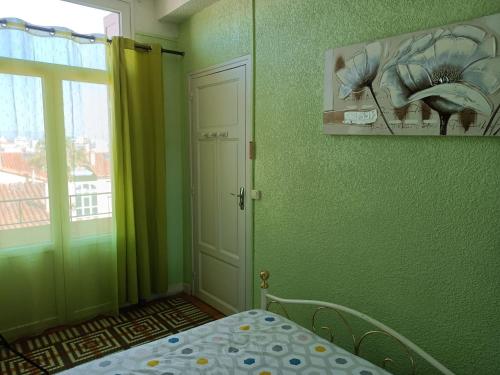 a bedroom with a bed and a window and a door at Hostel-Élisée-Perpignan in Perpignan