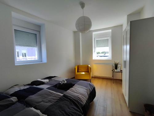 - une chambre avec un lit et une chaise jaune dans l'établissement #Lesgourmandises, à Mulhouse
