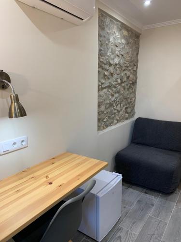 a room with a desk and a blue chair at Hostal Milana Girona in Girona