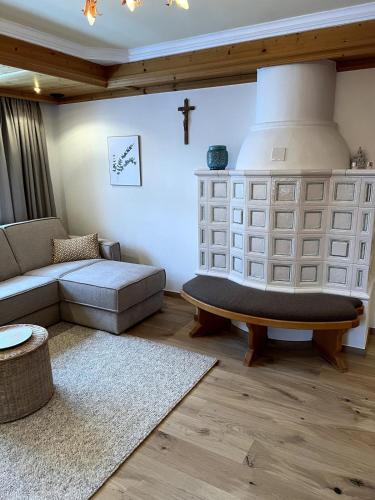 a living room with a couch and a cross on the wall at Ferienwohung Walcher in Grossarl
