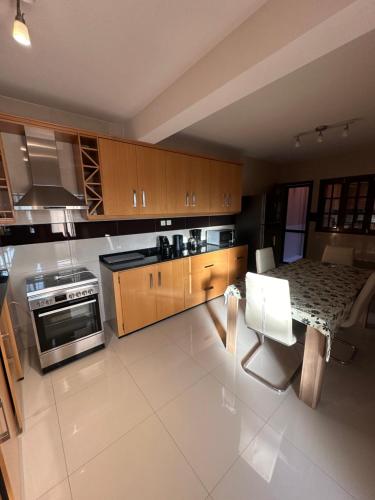 una grande cucina con mobili in legno e un tavolo di Casa Lima a Mindelo