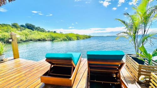 two chairs on a wooden deck overlooking a river at CoralBay Bungalows Solarte in Solarte