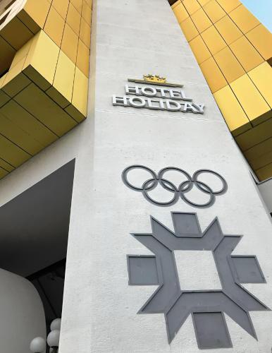 a sign on the side of a building with the olympic rings at Hotel Holiday in Sarajevo