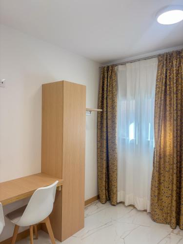 a room with a desk and a window with curtains at Fuentes de luz in San Sebastián de los Reyes