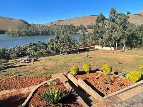 a garden with a view of a river and mountains at Shyalongubo dam cabin in Barberton