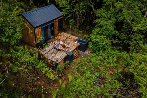 Un uomo seduto su una panchina di fronte a una casetta di Tiny House with Views and Jacuzzi in Anton Valley a Las Colinas