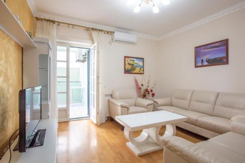 a living room with a couch and a table at Luxury Apartments Montesan in Sveti Stefan