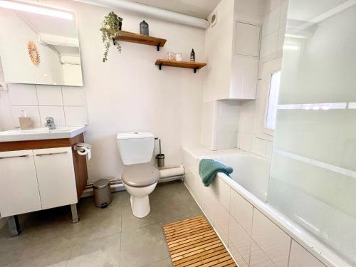 a white bathroom with a toilet and a shower at L'Antique - Cocon, Centre Historique, Wifi , 4 lits, 6 personnes in Istres