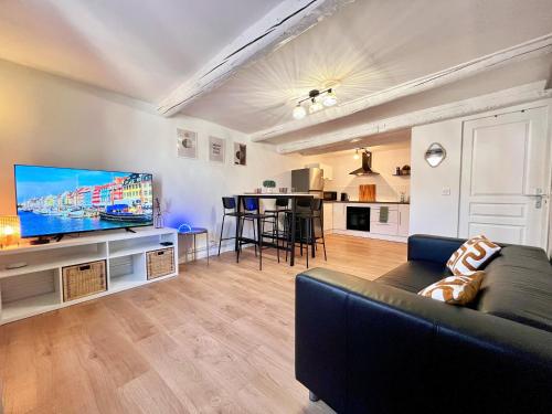 a living room with a couch and a flat screen tv at L'Antique - Cocon, Centre Historique, Wifi , 4 lits, 6 personnes in Istres