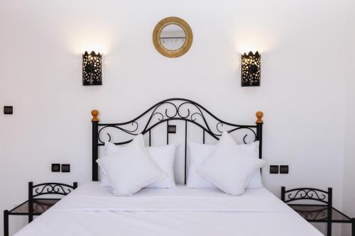 una camera da letto con un letto bianco e nero con cuscini bianchi di Cosy Studio a Marrakech