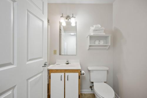 a bathroom with a toilet and a sink and a mirror at Affordable Suites Conover / Hickory in Conover