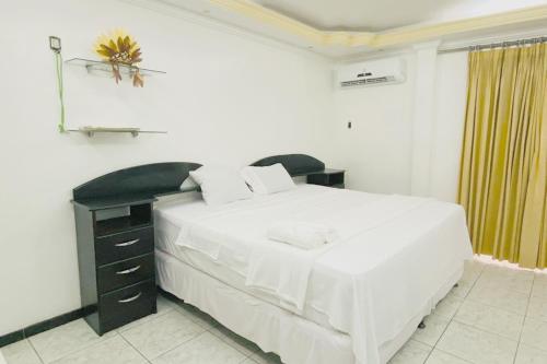 a bedroom with a large white bed and a desk at Riverfront Retreat Prime Location Apartment with Stunning Views of the RioNegro in Manaus