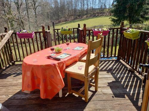 a table with a red table cloth on a deck at La Grange in Saint-Agnant-près-Crocq