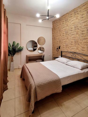 a bedroom with a large bed and a brick wall at CITY CENTER APARTMENT in Sparti