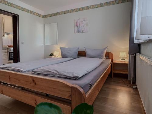 a bedroom with a large bed with blue sheets at FeWo Schiffsblick - Horumersiel in Horumersiel