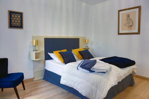 - une chambre avec un lit doté d'oreillers jaunes et bleus dans l'établissement Les Templiers, à Dole