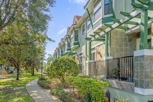 a building with green trim and a sidewalk at Your Summer Getaway Awaits - Townhome by Disney! in Orlando