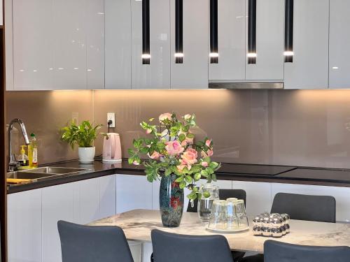 a vase of flowers on a table in a kitchen at Vinh Hoi Apartments - Luxury Apartment Furnished Suites in Ho Chi Minh City
