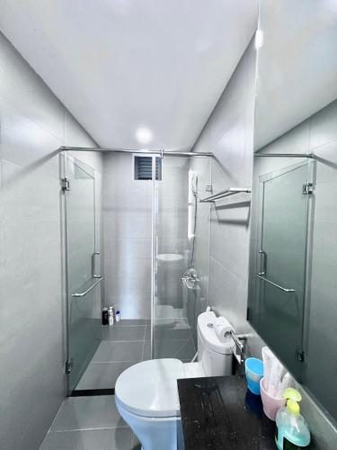 a bathroom with a toilet and a glass shower at Vinh Hoi Apartments - Luxury Apartment Furnished Suites in Ho Chi Minh City