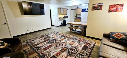 a living room with a couch and a rug on the floor at 1Bd, King, Brkfst, Large TVs, WD, Sleeps 4, BBQ in Page
