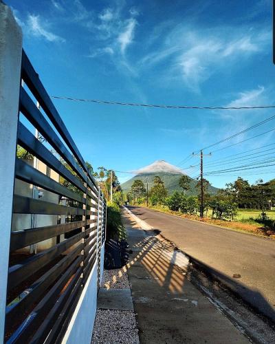 a fence on the side of a road with a mountain at Fortuna Tropical Loft in Fortuna