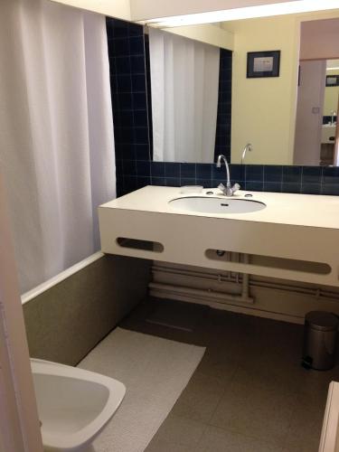 une salle de bain avec un lavabo, des toilettes et un miroir dans l'établissement Bordeaux - Appartement avec terrasse, à Bordeaux