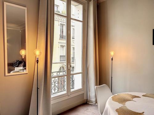 - une chambre avec une fenêtre donnant sur un bâtiment dans l'établissement Executive Apartment - Hotel Particulier, Paris 16, à Paris